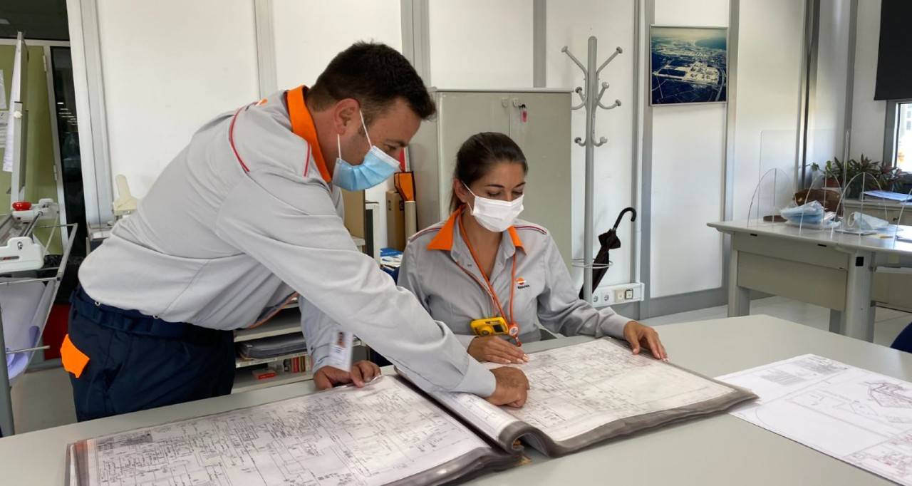 Dos empleados de la refinería consultando un mapa
